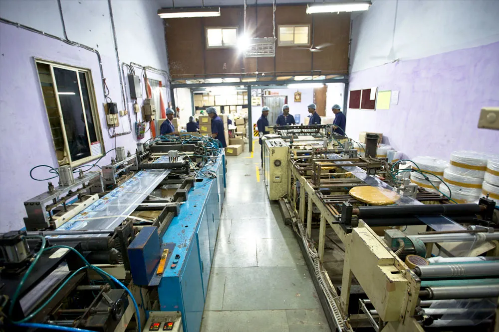 Bag-making machines running in the workshop with operators at the far end