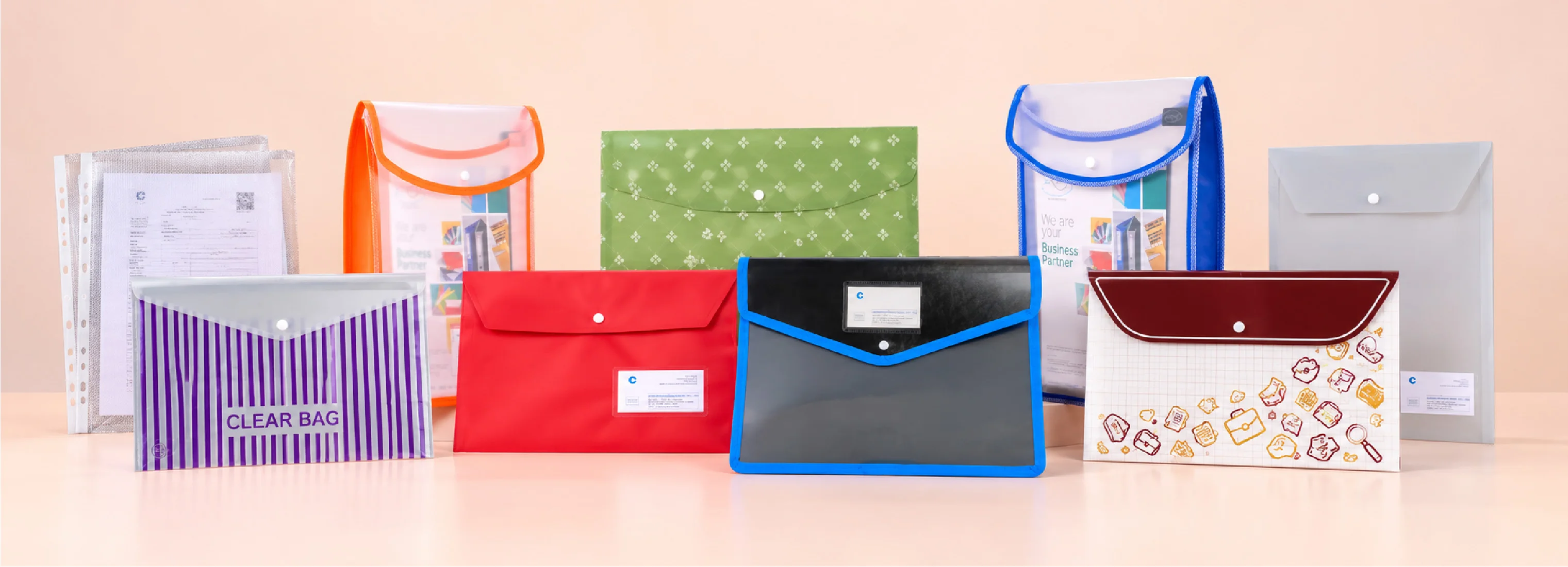Aarpee document folders and clear bags — button wallets, an expanding wallet, and printed folders — arranged on a warm peach surface
