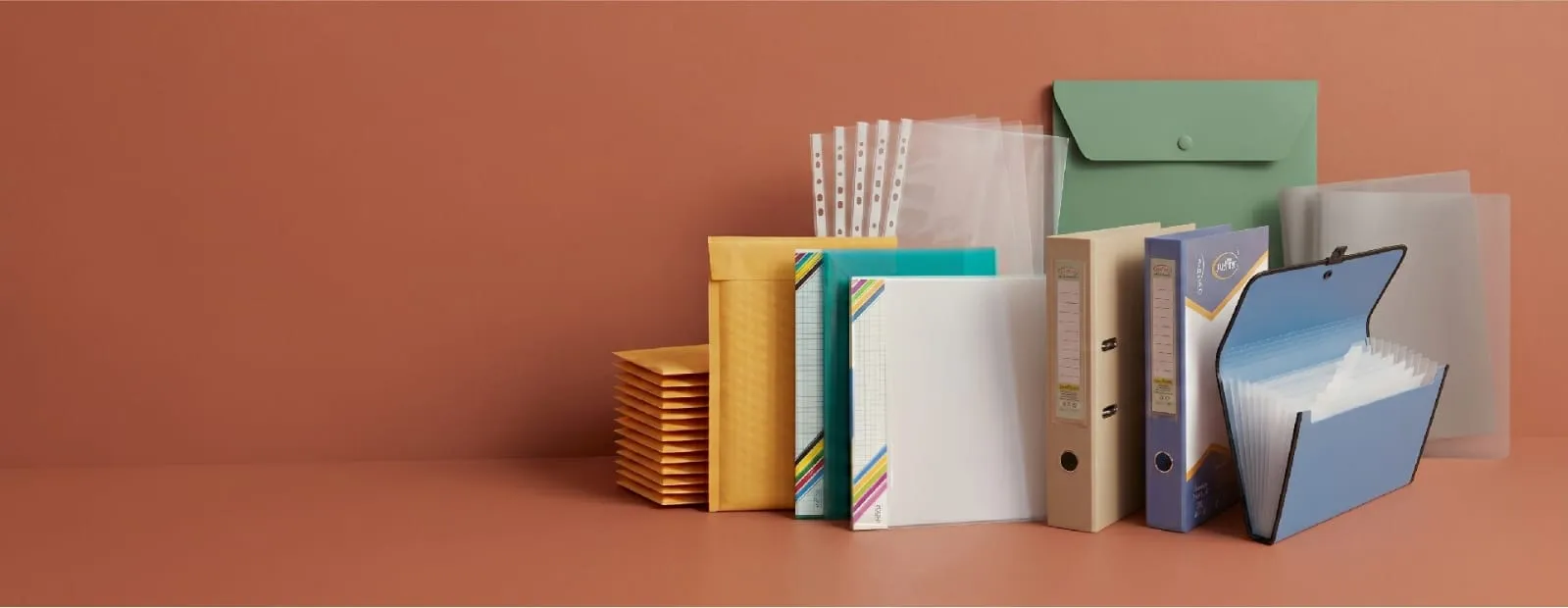 Aarpee stationery products arranged on the right against a terracotta studio background