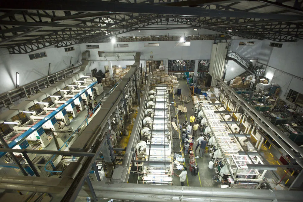 Overhead view of the production floor with long converting lines running the length of the hall